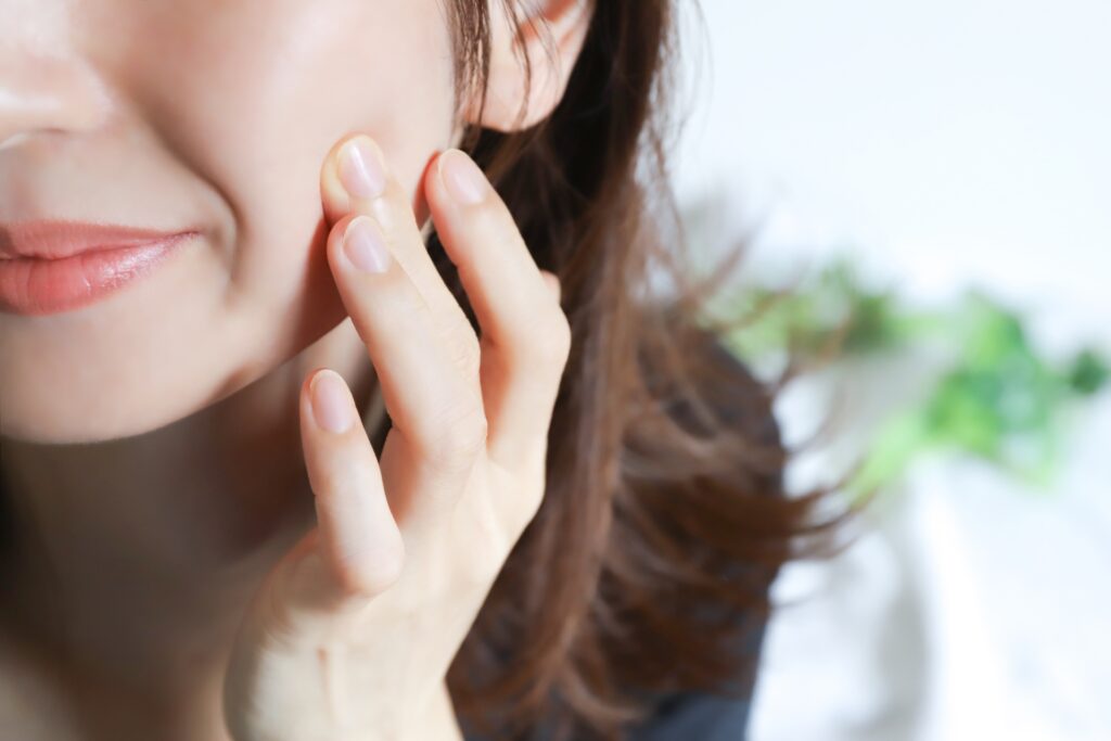 女性が肌を指で押している