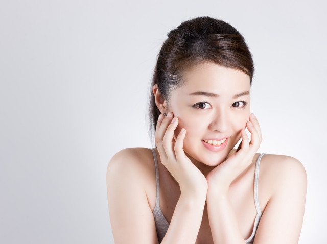 女性が笑顔で顔に手を当てている様子