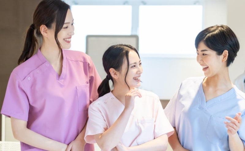 3人の女性スタッフが笑顔で会話している