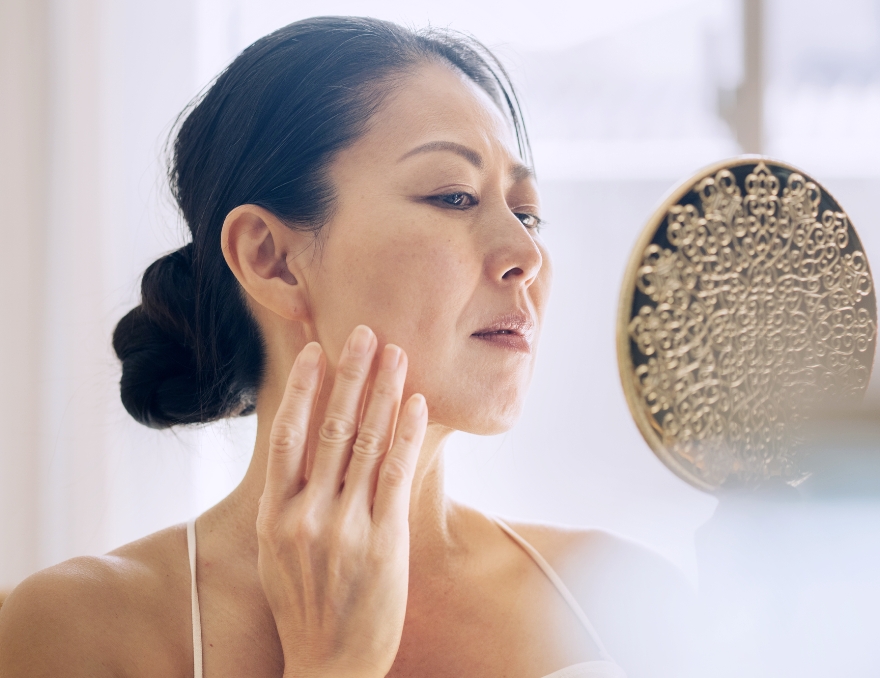 手鏡を片手に肌の状態を見る女性