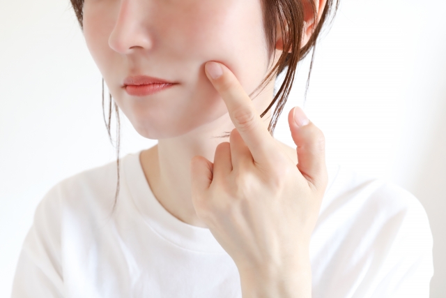 頬を触る女性