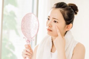 鏡を見ながら悩んでいる女性