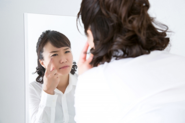 目元に悩んでいる女性