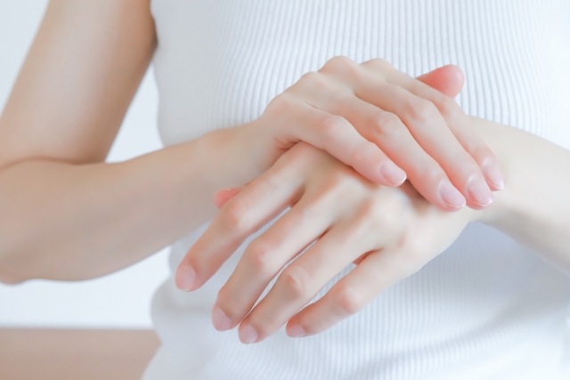 両手を重ねている女性