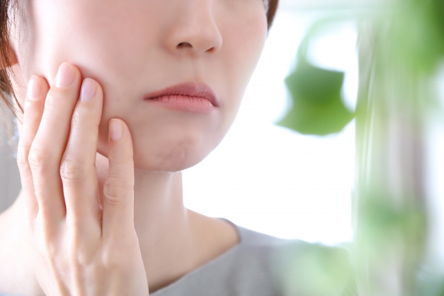 頬を触る女性